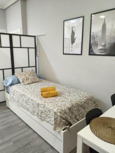 a bedroom with a bed with a yellow blanket at El Molar Loft in El Molar