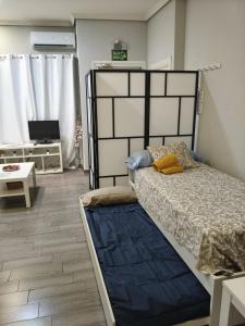a bedroom with a large bed with a blue blanket at El Molar Loft in El Molar