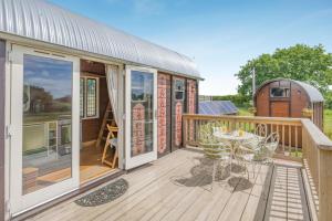 a deck with a table and chairs on a house at 1 Bed in Elsing oc-d44228 in Elsing