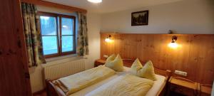 a bedroom with a bed with two pillows and a window at Familienhof Kain in Tiefgraben