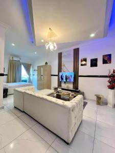 a large living room with a couch and a tv at Luxury studio apartment in Accra +9 photos
