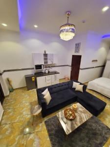 a living room with a black couch and a table at Luxury studio apartment in Accra