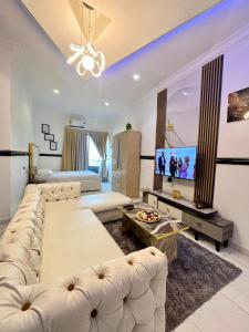 a living room with white furniture and a tv at Luxury studio apartment in Accra