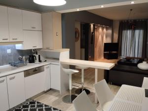 a kitchen with white cabinets and a table and chairs at Despina's apts in Kalamariá