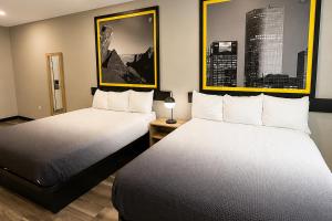 two beds in a hotel room with two beds sidx sidx sidx at Super 8 by Wyndham Brenham TX in Brenham +40 photos