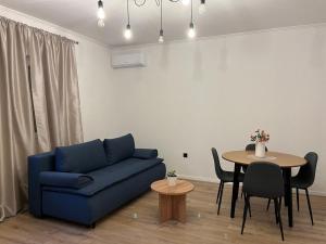 a living room with a blue couch and a table at Apartmani KIKO in Međugorje
