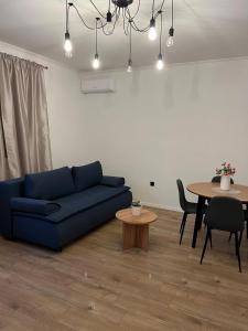 a living room with a blue couch and a table at Apartmani KIKO in Međugorje +14 photos