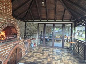 an outdoor living room with a brick fireplace at Pensiunea Eden in Bărăşti