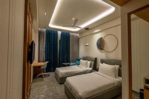 a hotel room with two beds and a mirror at Hotel Vintana in Nananpur