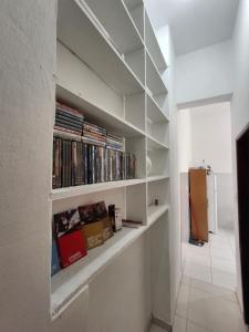 a room with white shelves with books at Quarto Confortável no Centro - Bela Ilha House in São Luís