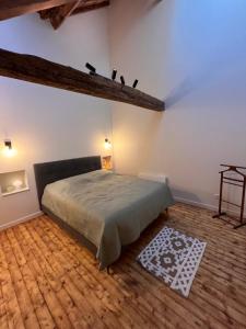 a bedroom with a bed and a wooden floor at appartement chaleureux in Honfleur