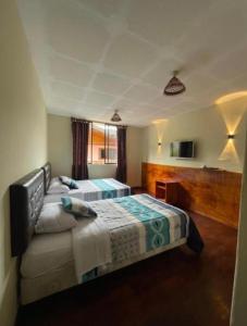 a bedroom with two beds and a window at GoldenBird Mindo in Mindo +3 photos