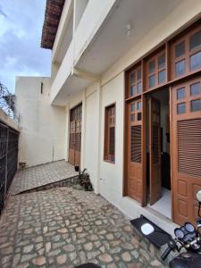 a building with wooden doors and a stone walkway at Quarto Confortável no Centro - Bela Ilha House in São Luís