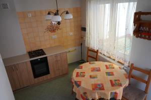 a kitchen with a table and a kitchen with a window at Dom Wypoczynkowy IRMINA in Karwia