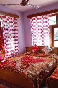 a bedroom with a bed with red and white curtains at Khan Camping Naranag in Sonāmarg