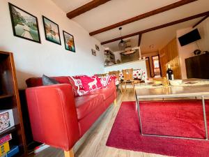 a living room with a red couch and a red rug at LOVErbier with pool in building, steps to Place Central in Verbier