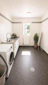 a kitchen with a washing machine and a sink at Villa Kaxberg in Södertälje