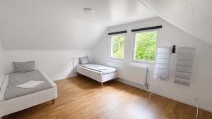 a white room with a bed and a window at Villa Kaxberg in Södertälje