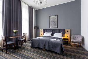 a bedroom with a bed and a table and chairs at Hotel Bregenz in Berlin
