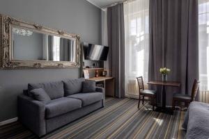a living room with a couch and a mirror at Hotel Bregenz in Berlin