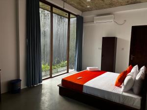 a bedroom with a large bed and a large window at Paris Garden Resort in Trincomalee +79 photos