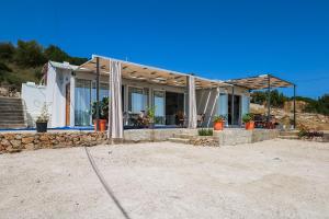 a house with a lot of windows and a stone wall at Vila Bliss in Ksamil