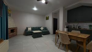 a living room with a green couch and a table at Pine villa sadgeri in Sadgeri