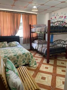 a bedroom with two bunk beds and a wooden floor at GoldenBird Mindo in Mindo