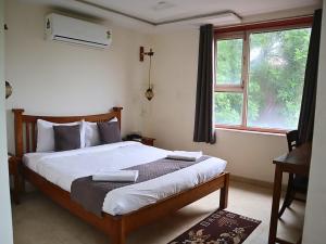 a bedroom with a large bed with a window at Jungle by sturmfrei Agra in Agra