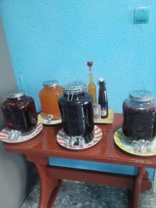 a table with three jars of jam and bottles of honey at Vila la Izvorul Putinei in Haţeg