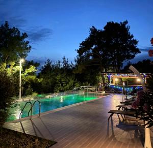 a swimming pool at night with people standing around it at Cosy Adriatic Studio in Kotor +7 photos
