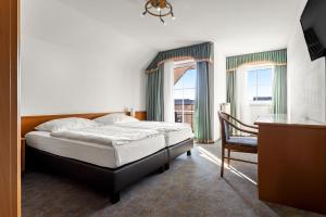 a bedroom with a bed and a desk and a chair at Landgasthaus Fischer in Bad Nenndorf +19 photos