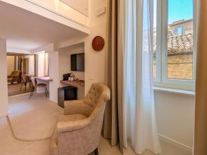 un soggiorno con una sedia e una finestra di Hotel Lauri a Macerata