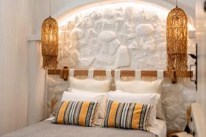a bed with white pillows in front of a wall at Boriadon Rustic Countryside Homes in Naxos Chora