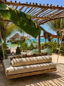 a swing on the beach with a view of the ocean at Villa Duara Zanzibar Rooftop Infinity Pool The Rock View in Michamvi