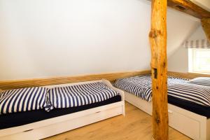 two twin beds in a room withthritisthritisthritisthritisthritisthritisthritisthritisthritis at Kapitänsdeck in Wustrow +7 photos