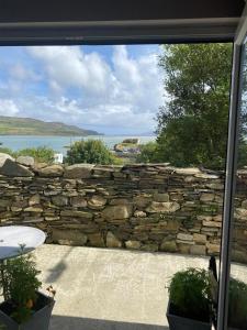 a stone wall with a view of the water at Central Two Bed Apartment looking over the Harbour in Dunfanaghy