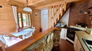 a kitchen with a counter and a table in a cabin at Chata uprostred lesa Modrová in Modrová