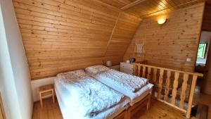 a bedroom with a bed in a wooden cabin at Chata uprostred lesa Modrová in Modrová