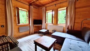 a living room with a couch and a table at Chata uprostred lesa Modrová in Modrová