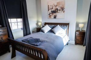 a bedroom with a bed with a blue blanket on it at Cosy Townhouse in Central Leamington with parking in Leamington Spa