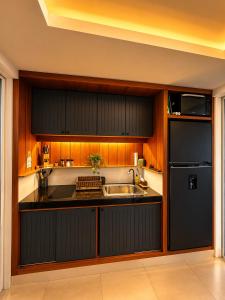 a kitchen with a sink and a black refrigerator at Aufwachen im Paradies Private Poolvilla 50 m vom Strand in Nathon Bay +23 photos