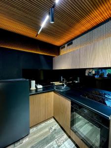 a kitchen with wooden cabinets and a black refrigerator at Dilijan House in Dilijan