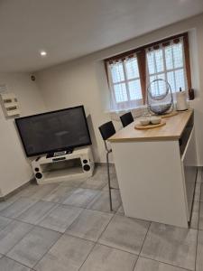 a living room with a flat screen tv and a kitchen at Joli rez de jardin in La Seyne-sur-Mer