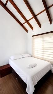 a bedroom with a white bed with a window at Isabelu in Guaduas +13 photos
