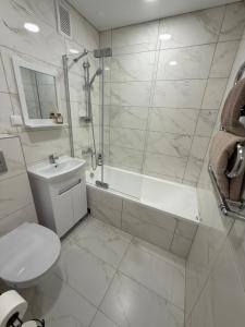 a bathroom with a toilet and a shower and a sink at Smiltelė apartamentai in Varėna +7 photos