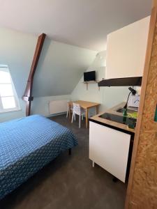 a room with a bed and a kitchen and a table at studio 3- les moulins in Cherbourg en Cotentin