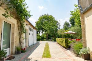 a walkway between two buildings with an umbrella at La Maison Des Buis in Falaise