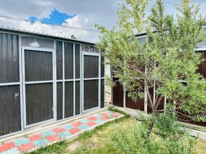 a house with a fence and a tree at Aspan Kazakh Ger Camp in Ölgiy