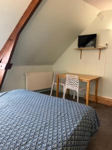 a bedroom with a bed and a table and a television at studio 3- les moulins in Cherbourg en Cotentin